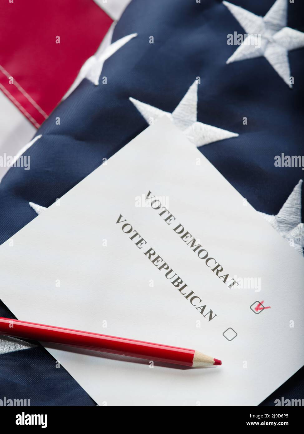 On the American flag is a ballot with a mark opposite the Democrat and a pencil. Elections, freedom of choice, politics, candidates, debates, civic du Stock Photo