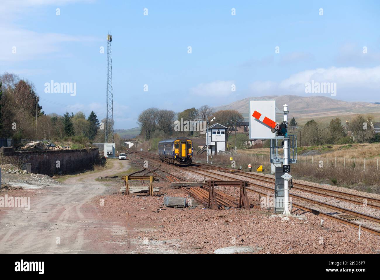 Scotrail class 156 sprinter train 156492 departing from  Kirkconnel with a mechanical signal box and semaphore railway signals Stock Photo