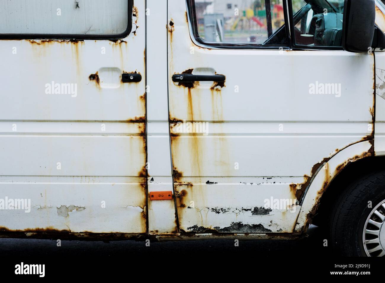 rust and corrosion of the car door. old worn painted metal surface