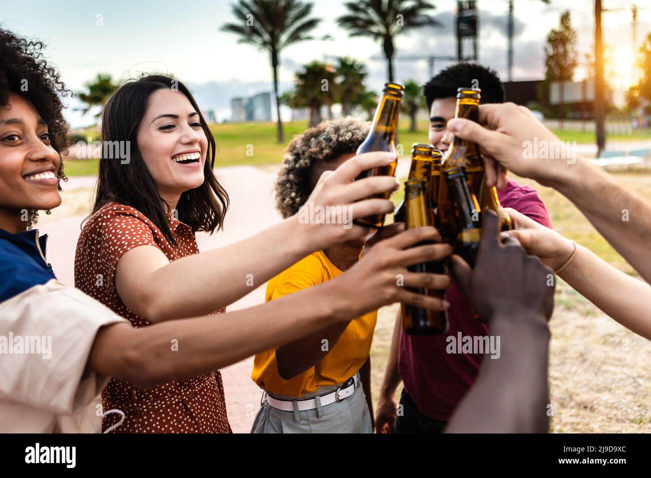 Group of diverse young friends drinking beer and having fun together on summer Stock Photo
