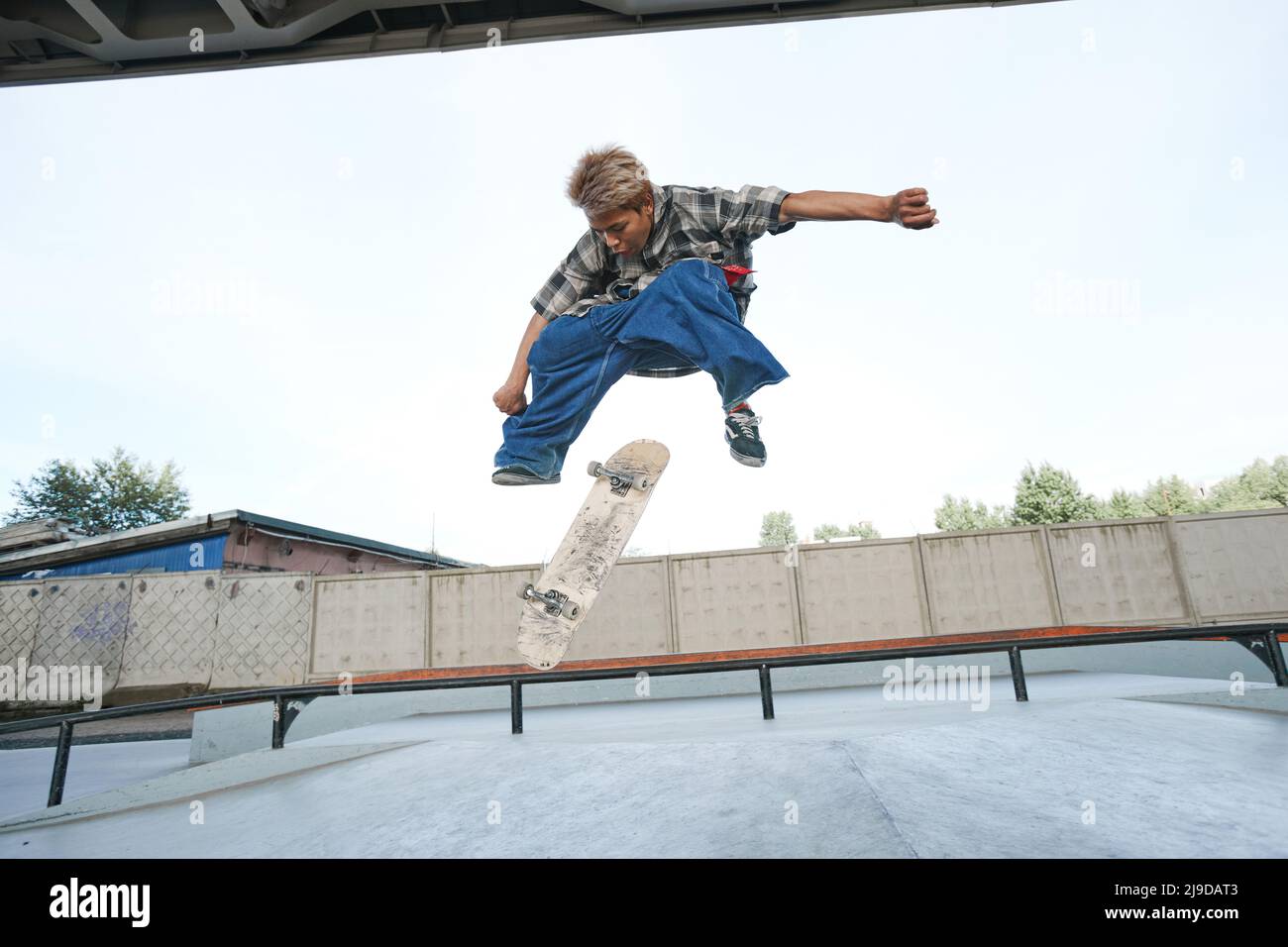Portrait of teenage boy doing skateboard tricks in air at outdoor skatepark  in urban area Stock Photo - Alamy