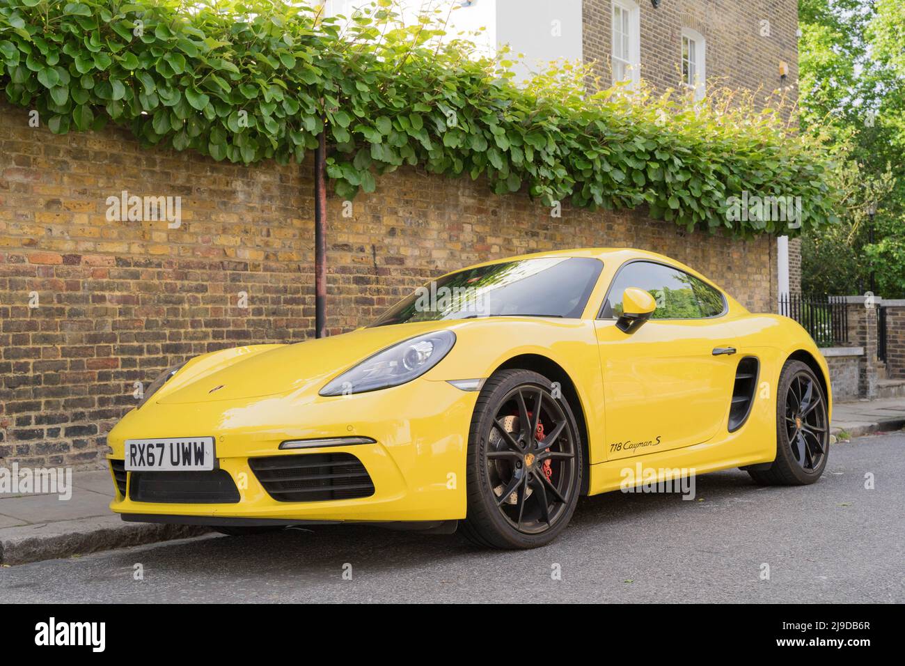 front offside view of a yellow PORSCHE parks at road side on street parking bay, Greenwich London England Stock Photo