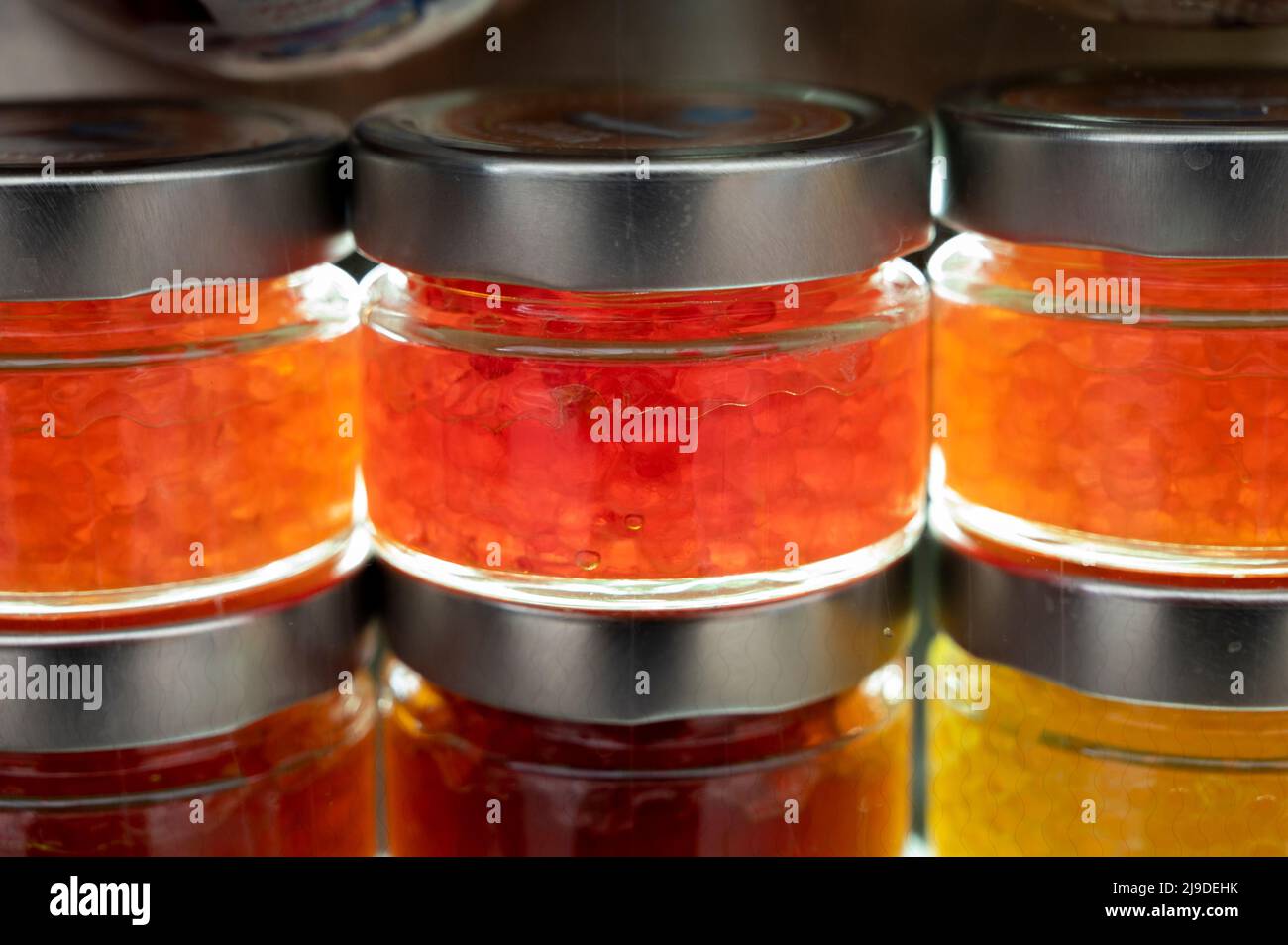 Small glass cans with real fish salmon and trout red, orange and yellow ...