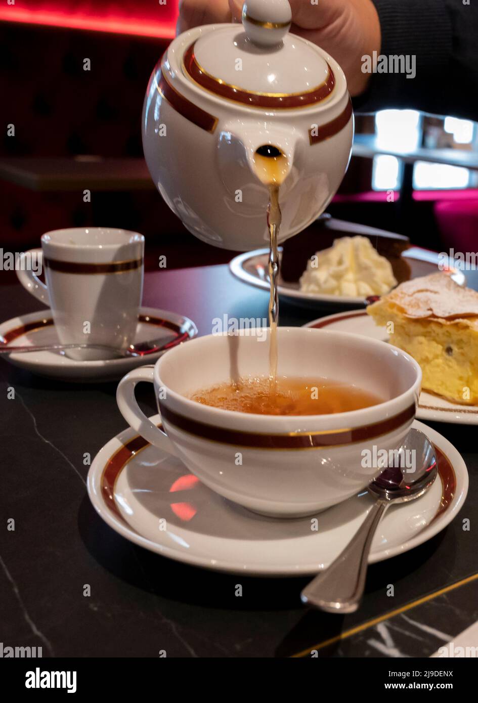 Tea time in England, pouring of black earl grey tea with bergamot in