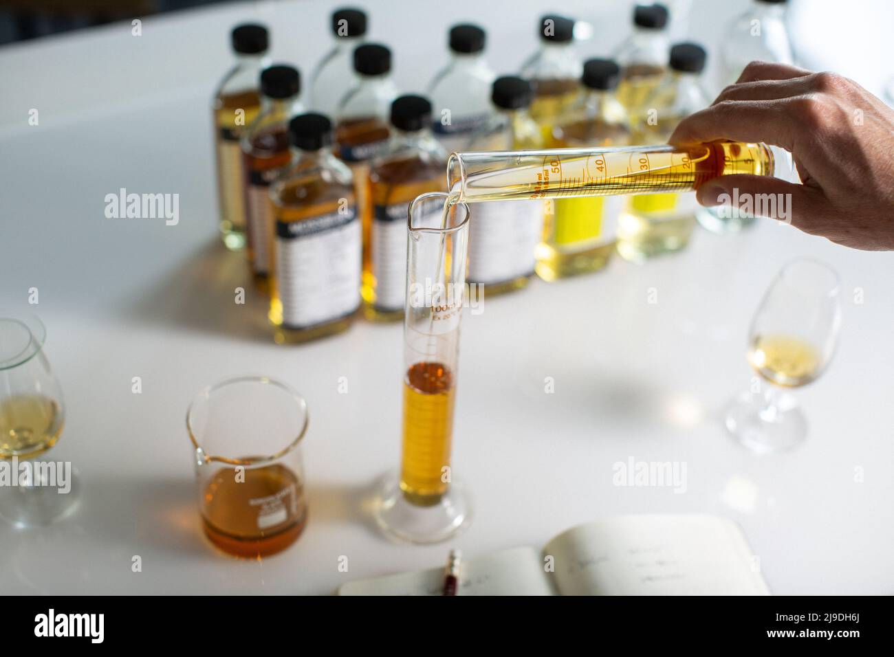 Single malt whisky blending . Whisky blender taking note Stock Photo