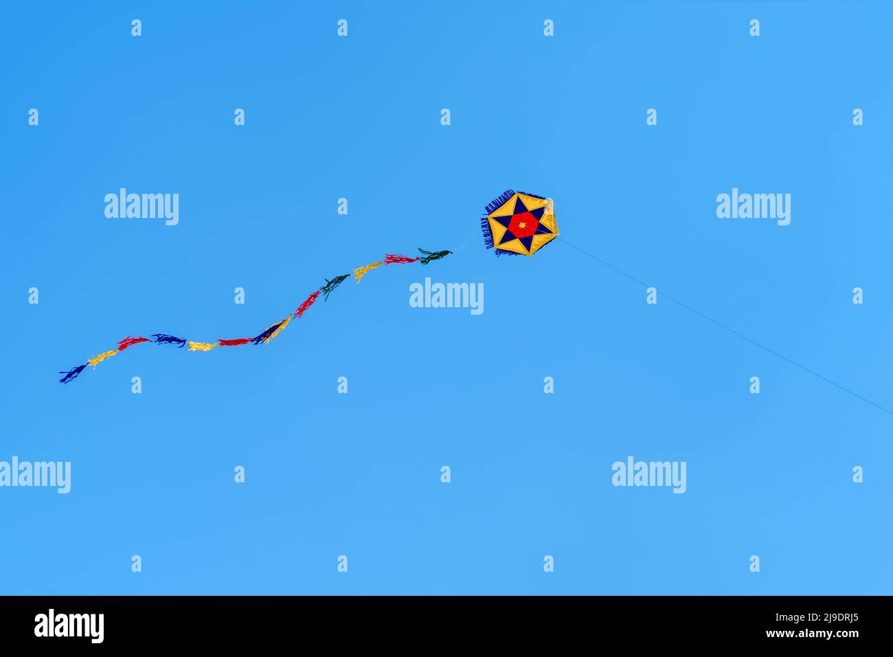 A colorful round kite soars high in the sky Blue sky. Sports kite