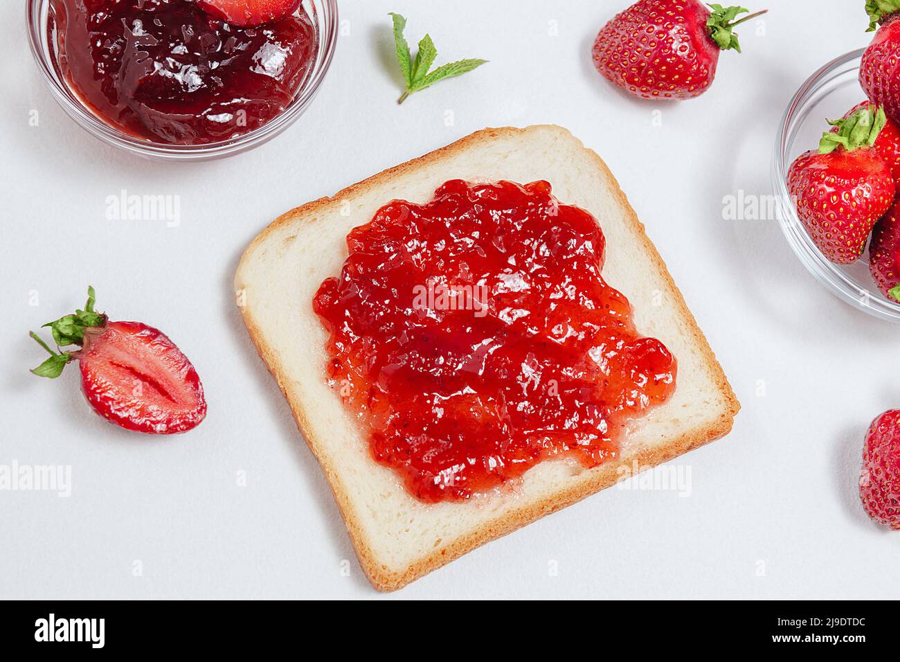 Toasts with strawberry jam for breakfast on white background. Top view
