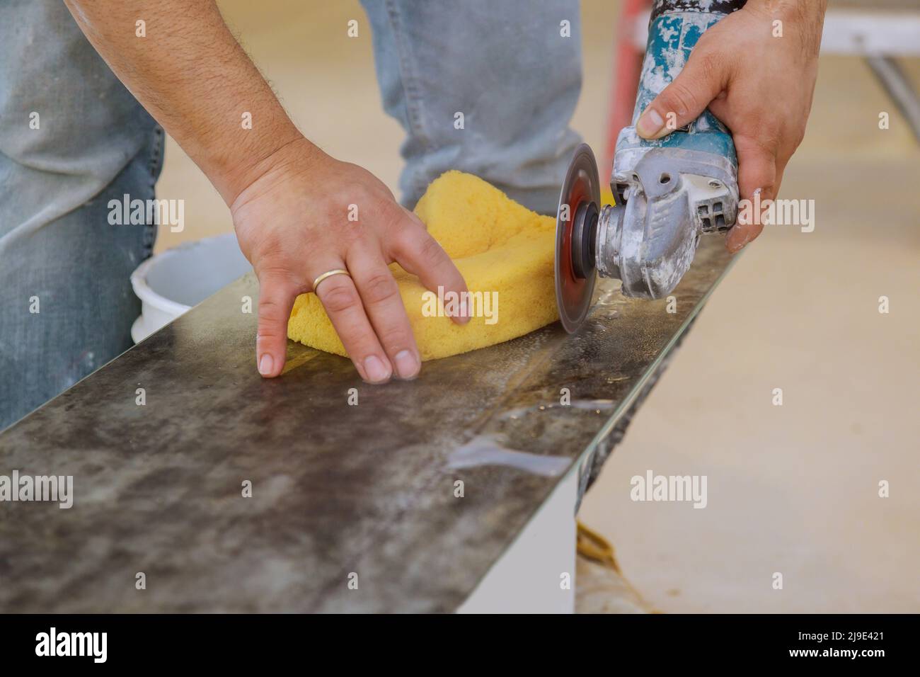 Worker hands cutting the floor ceramic tile by circular saw Stock Photo