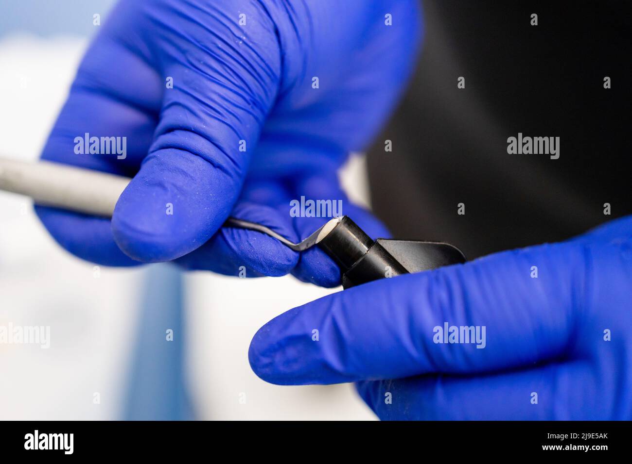 Dentist putting dental plugger into composite resins vial. Composite filling material used in dentistry Stock Photo