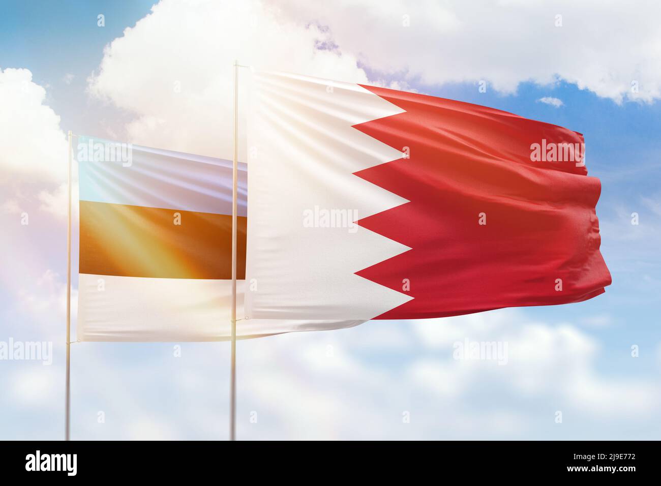 Sunny blue sky and flags of bahrain and estonia Stock Photo
