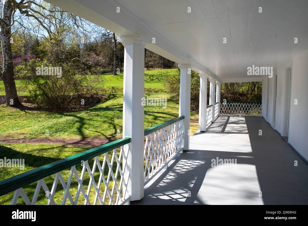 View down the long covered front porch of a colonial American home Stock Photo