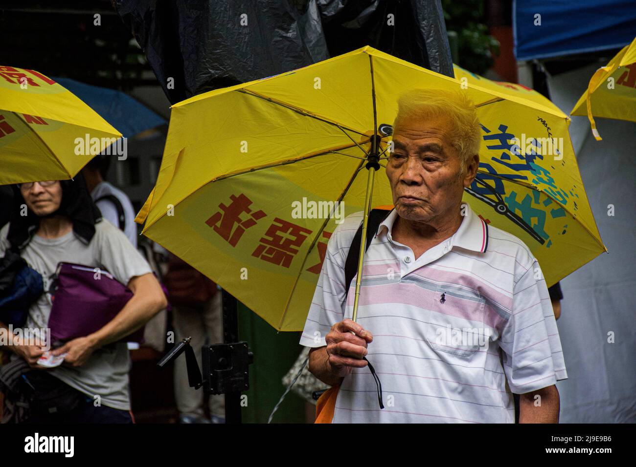 A man holding a yellow umbrella, a symbol of Hong Kong's prodemocracy movement originated from