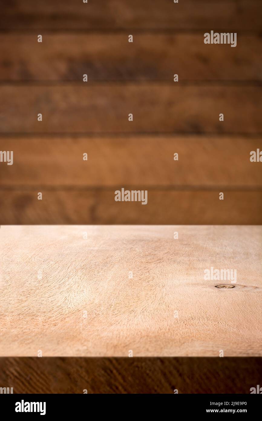 empty wooden table top and blurry wood plank wall, food or product photography background or backdrop, side view in shallow depth of field, copy space Stock Photo