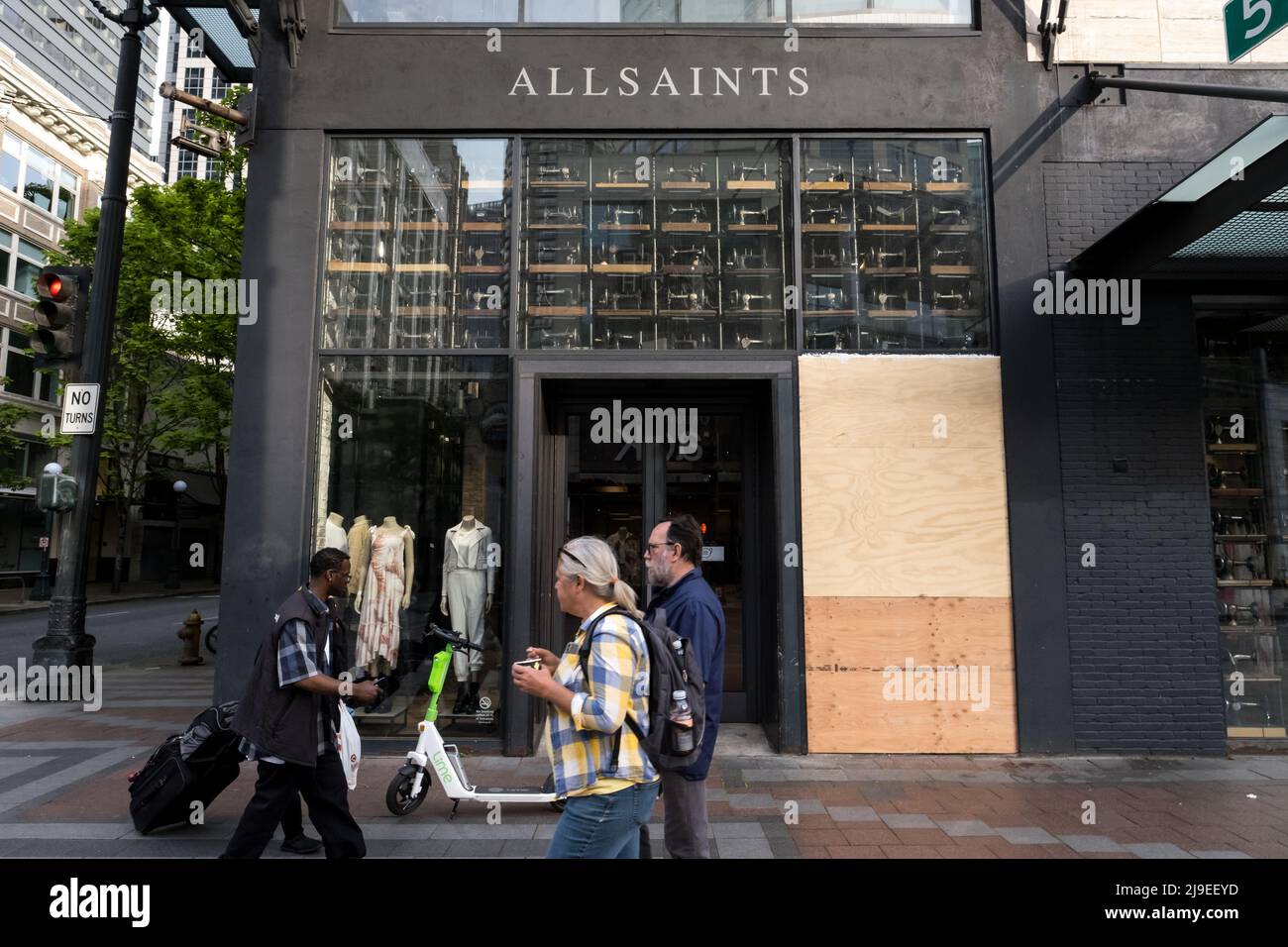 Seattle, USA. 22nd May, 2022. A smashed front Window at All Saints on Pine  and 5th in Westlake as people pass by. Just one of the businesses  continuing to be vandalized in