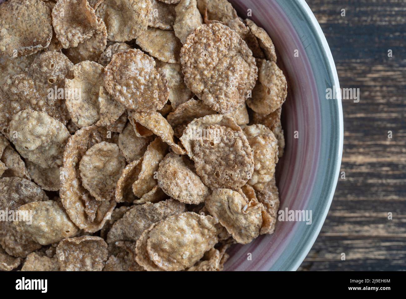 Whole grain glazed flakes in plate, close up, top view. Healthy