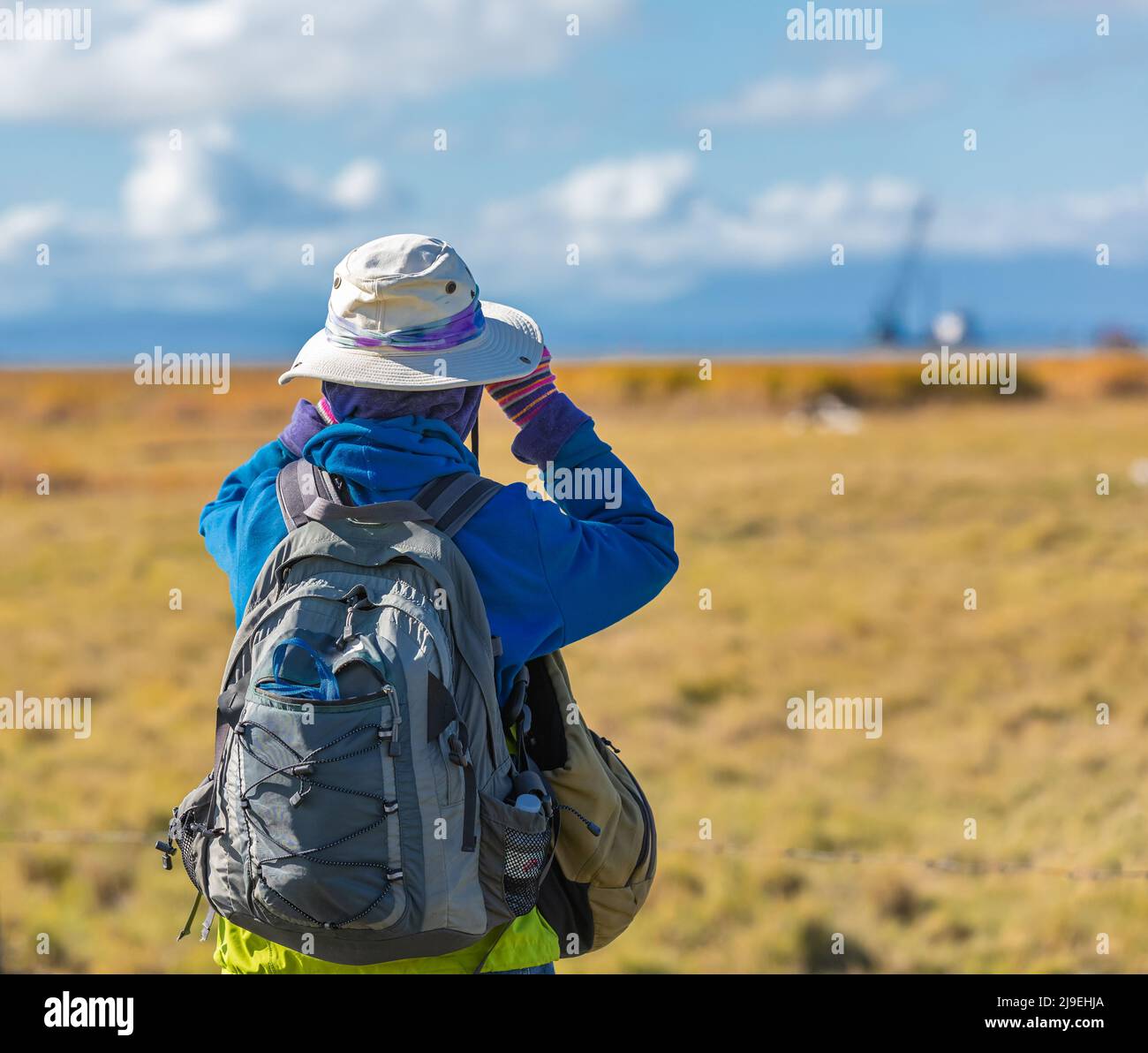 Hiking women use binoculars to travel and have a backpack. Traveler