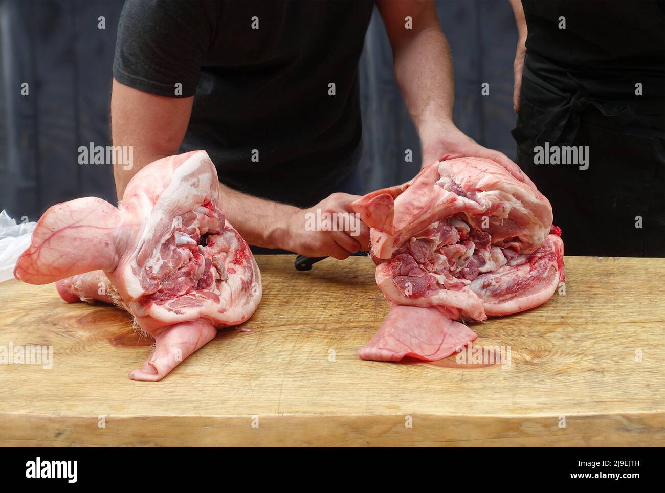 Two pigs heads on a butchers block Stock Photo