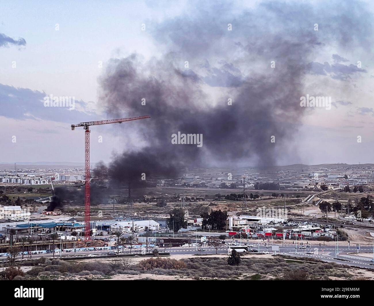 black smoke billows from a small building in an industrial and warehouse district of a city in the Negev region in Israel Stock Photo