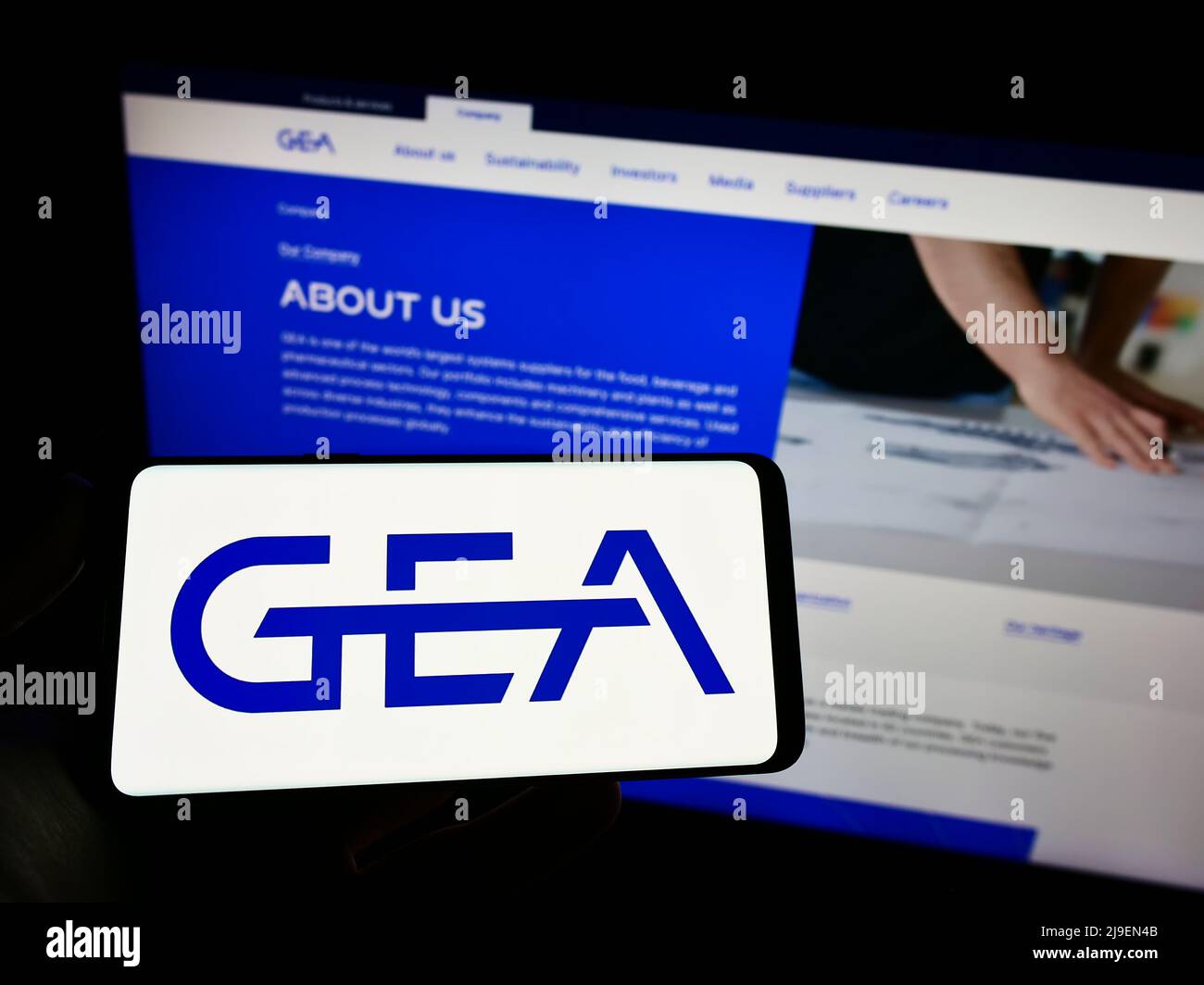 Person holding cellphone with logo of German food processing company