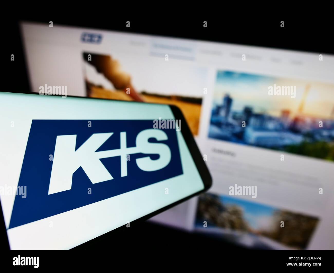 Mobile phone with logo of German mining company KS AG (K plus S) on screen in front of business website. Focus left of on phone display. Stock Photo