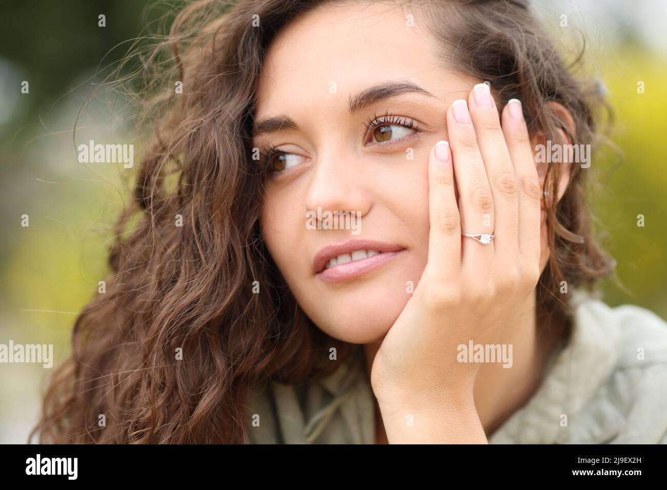 Confident woman showing engagement ring looking at side after proposal Stock Photo