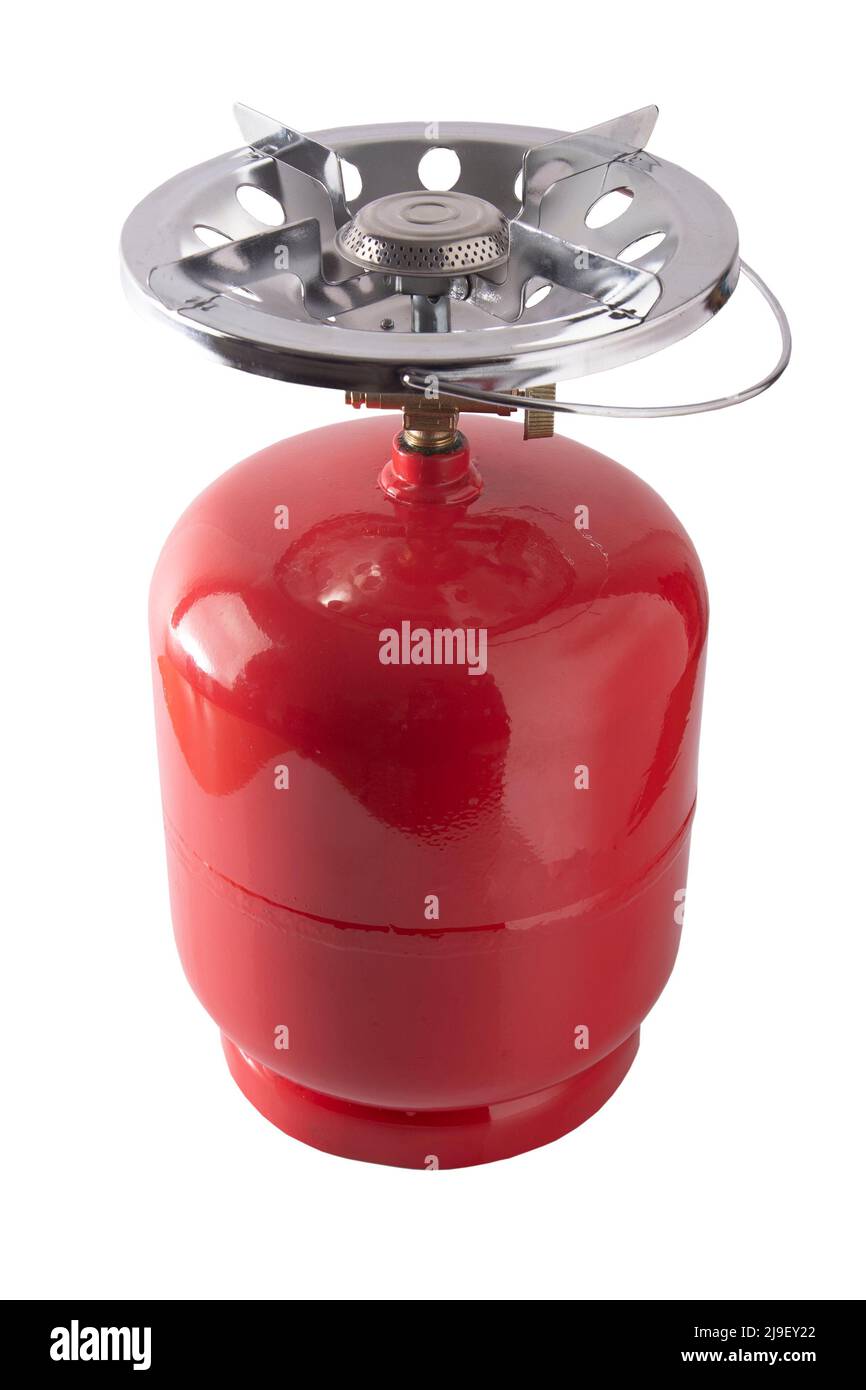 Portable gas bottle. A small compact travel bottle with a burner for cooking on a hike. The road gas stove is filled with propane. Red tank. Stock Photo