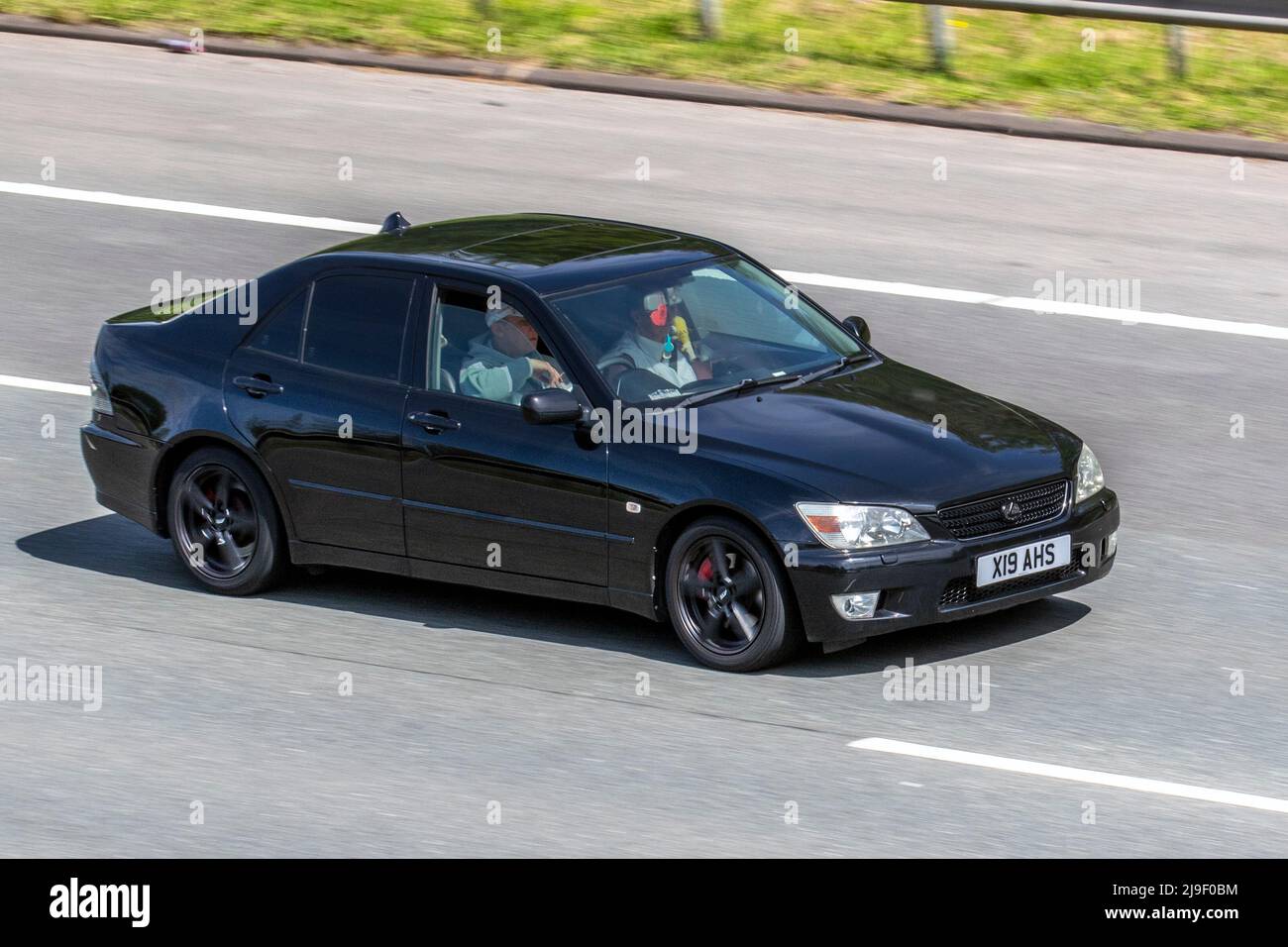 2003 black LEXUS IS200 SE 1988cc petrol 6 speed manual 4dr, driving on the M61 Motorway, Manchester, UK Stock Photo