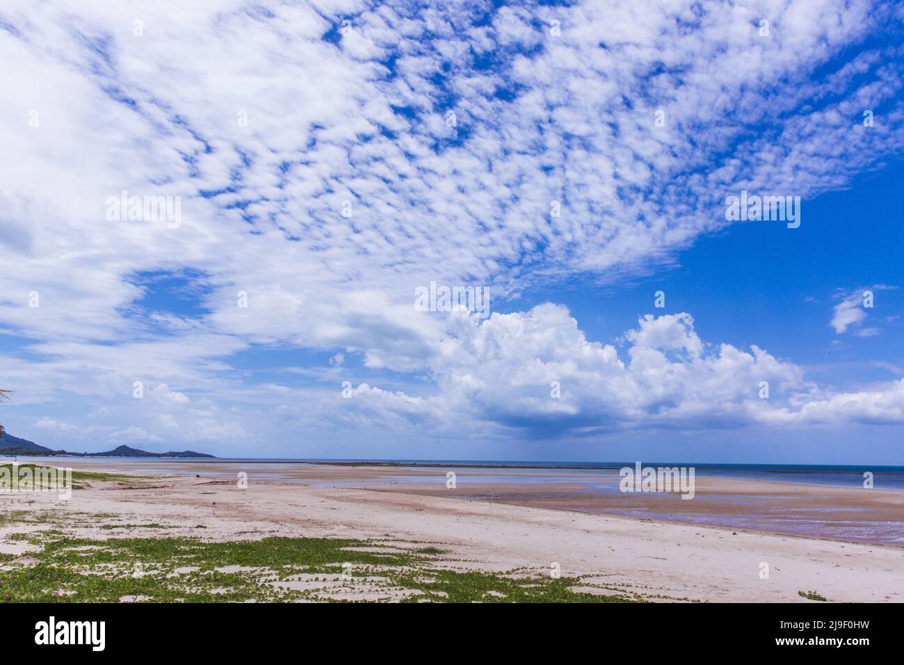 Tropical sandy beach and clear blue sea with beautiful sky with clouds ...