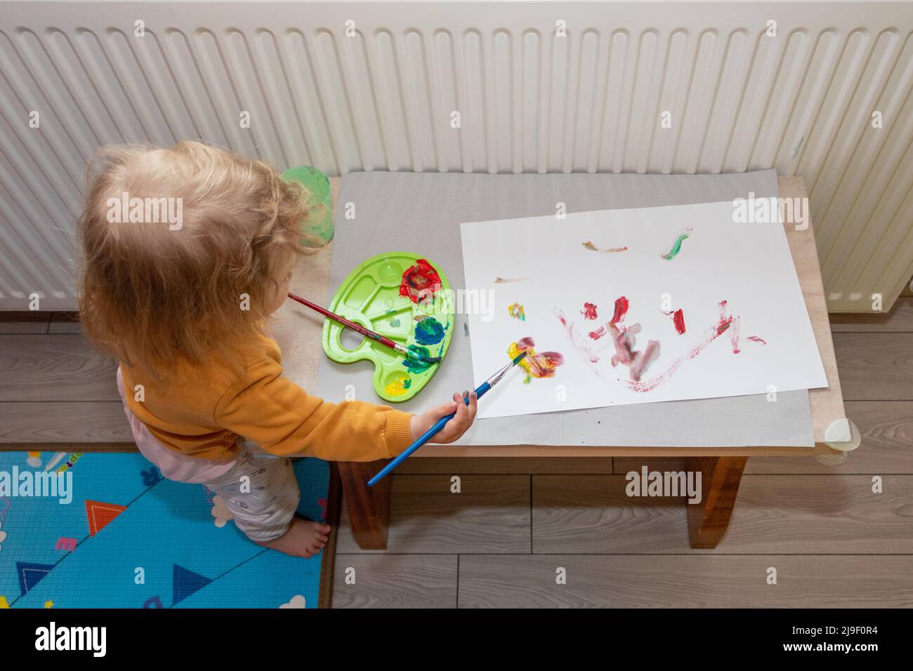 Preschool children cute little girl painting and drawing at home. Children development concept. Stock Photo