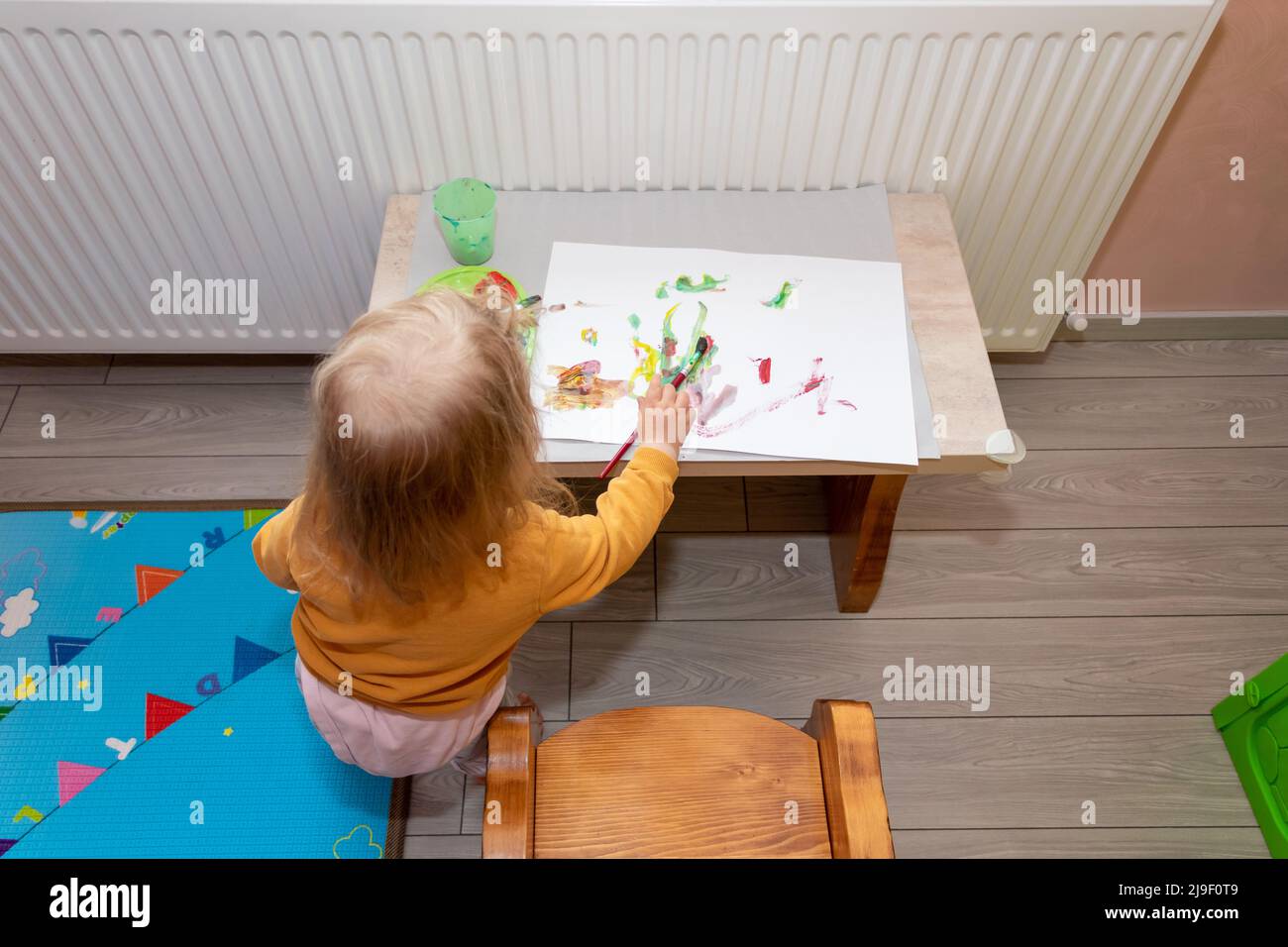 Preschool children cute little girl painting and drawing at home. Children development concept. Stock Photo
