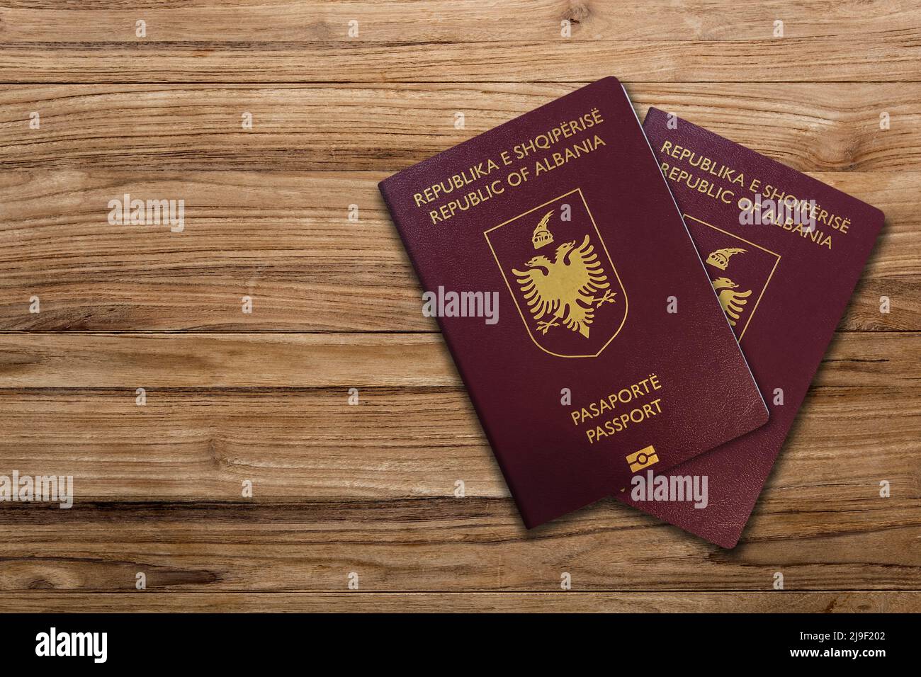 Albanian passport on a wood background ,Albanian passport is a travel document issued by the Ministry of Interior to Albanian citizens Stock Photo