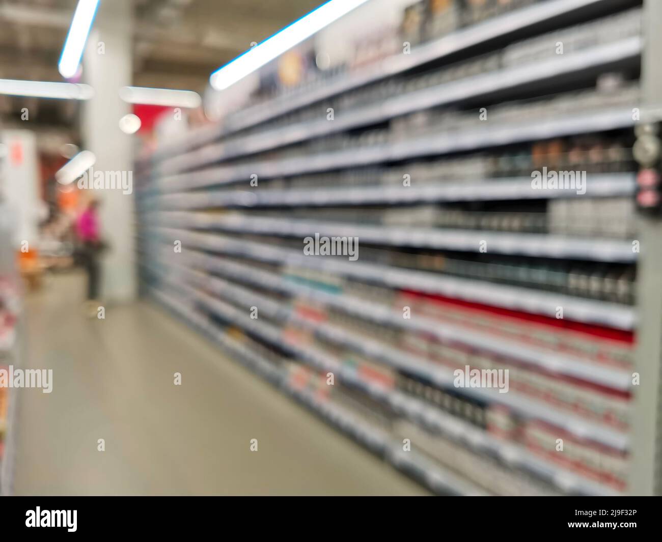 The background of a defocused image of a customer choosing goods in a modern building materials store. Stock Photo