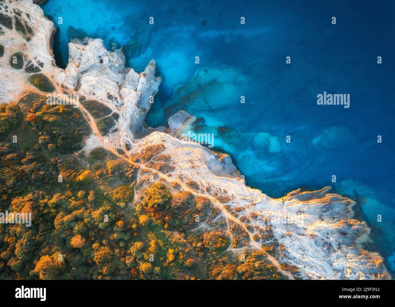 Aerial view of blue sea, rocks in clear water, beach, green trees Stock Photo