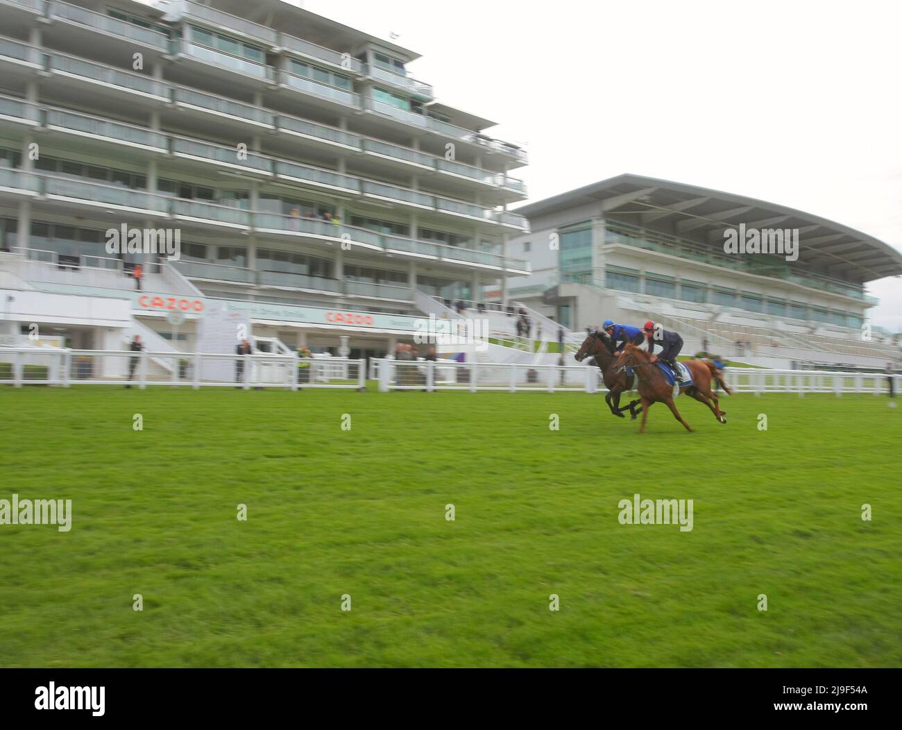 Epsom Downs, Surrey, UK. 23rd May, 2022. Runners for the Cazoo Derby and Oaks Classic horse races have a pre-event run out at the 'The Cazoo Derby Gallops Morning' on the Epsom Downs track. Here: Walk of Stars and Nahanni gallop past the empty grandstands Credit: Motofoto/Alamy Live News Stock Photo