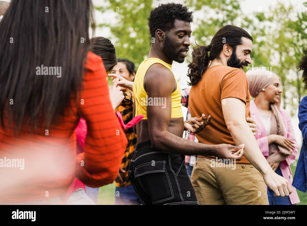 Young diverse people having fun outdoor dancing together - Focus on gay ...