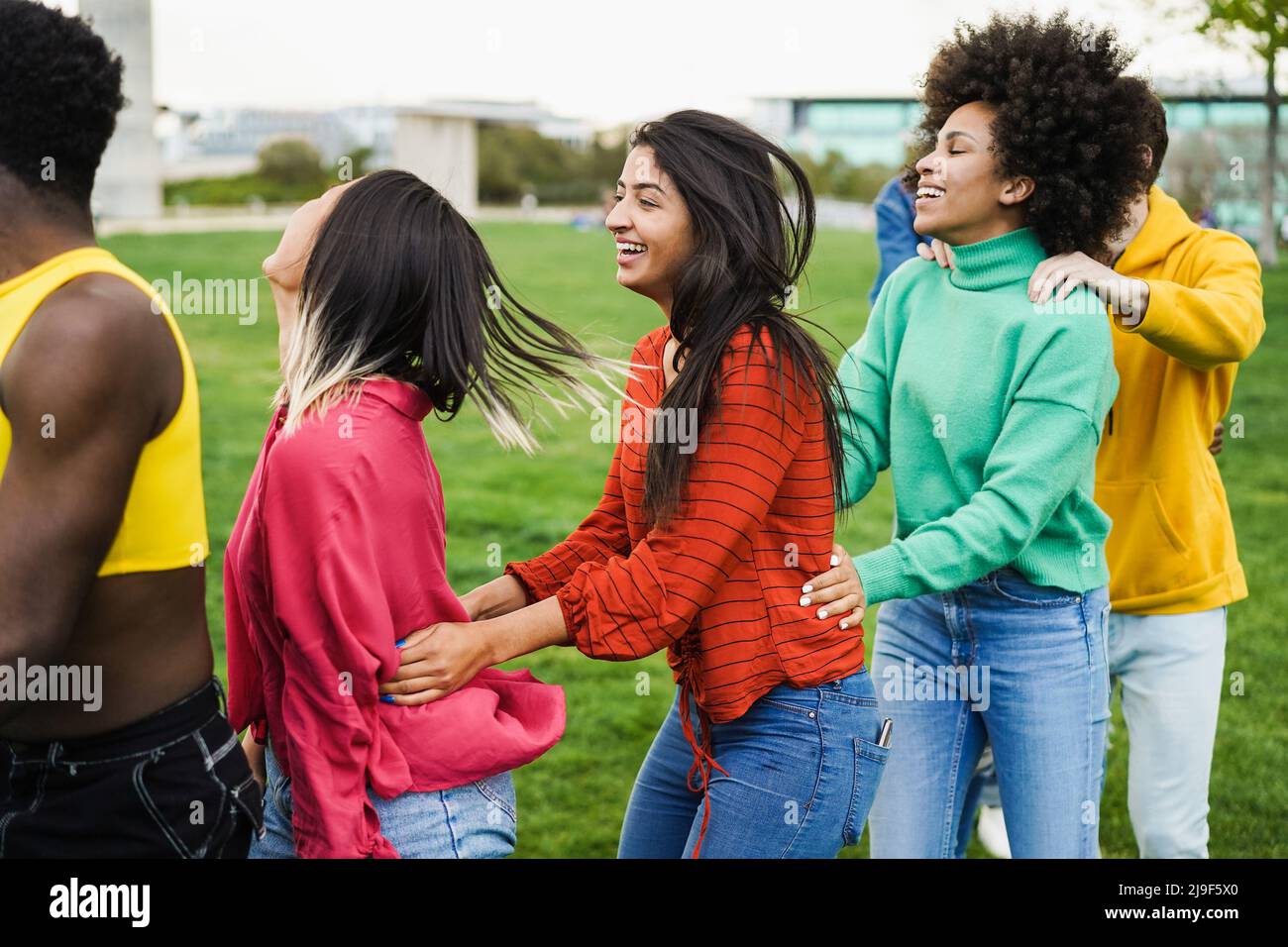 Young diverse people having fun outdoor dancing together - Focus on ...