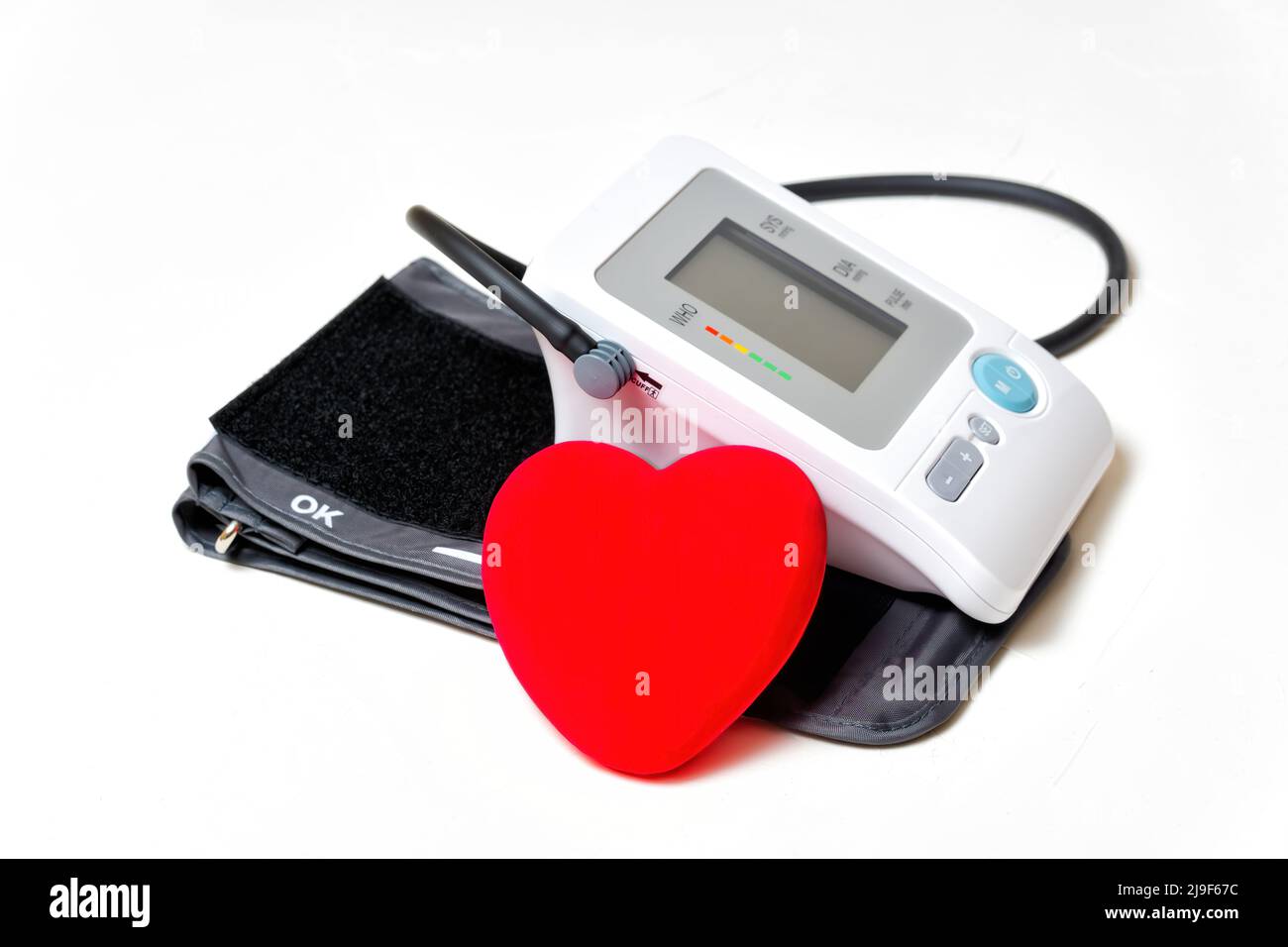 Blood pressure monitor with a large red heart isolated on white ...