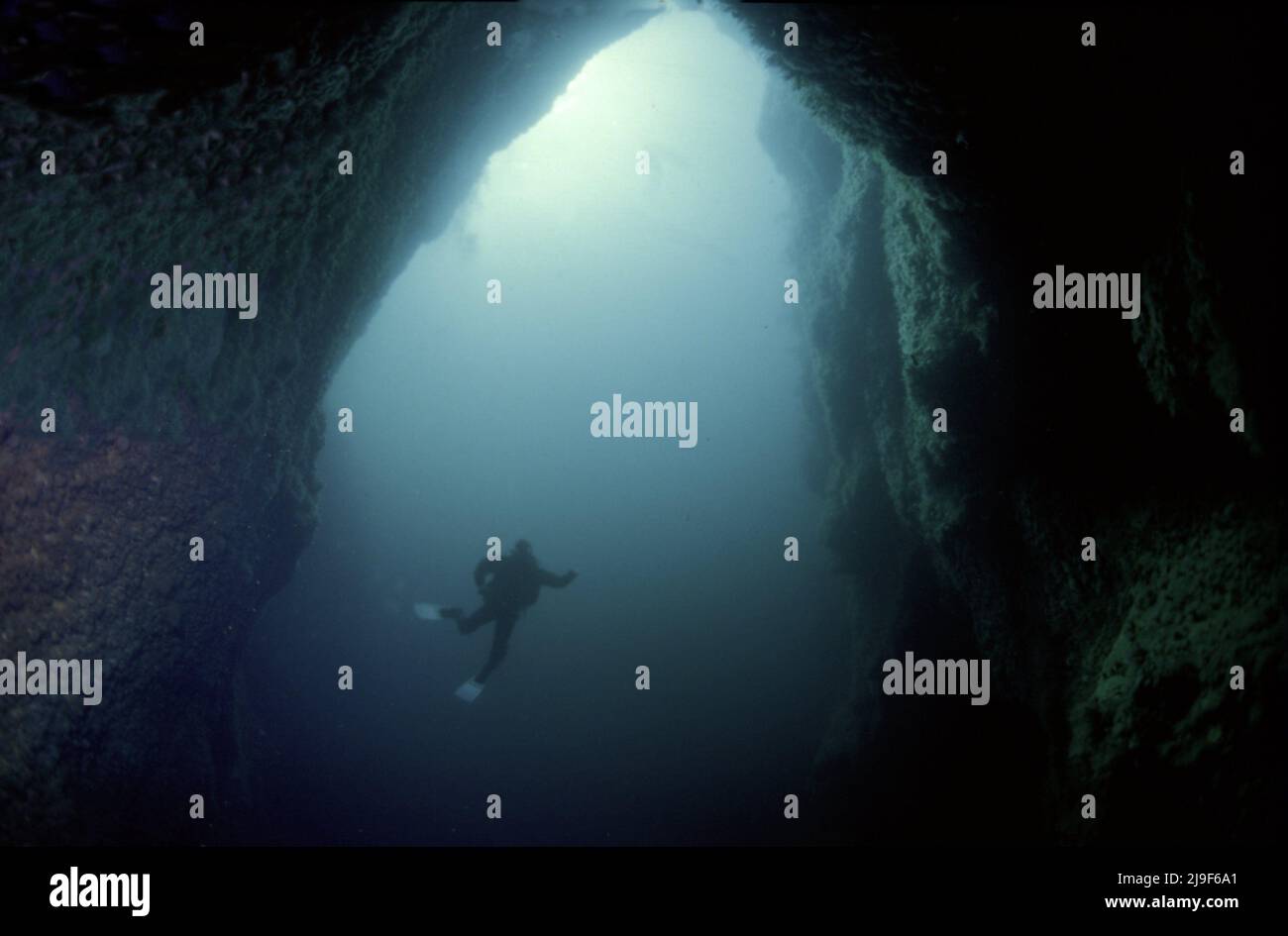 Sgarbhstat  Arch, Diver gives scale to the picture 40m below the surface, 30m through the arch, 20 m wide, and 50 m to the bottom Boreray, St Kilda UK. 1987 Stock Photo