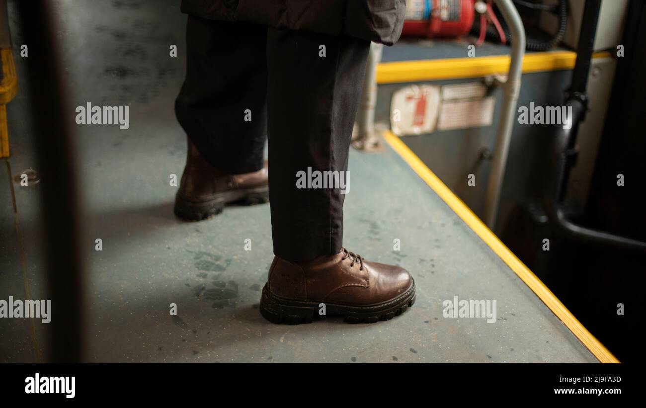 Brown shoes. Man in shoes. Man on bus. Autumn boots. Stock Photo
