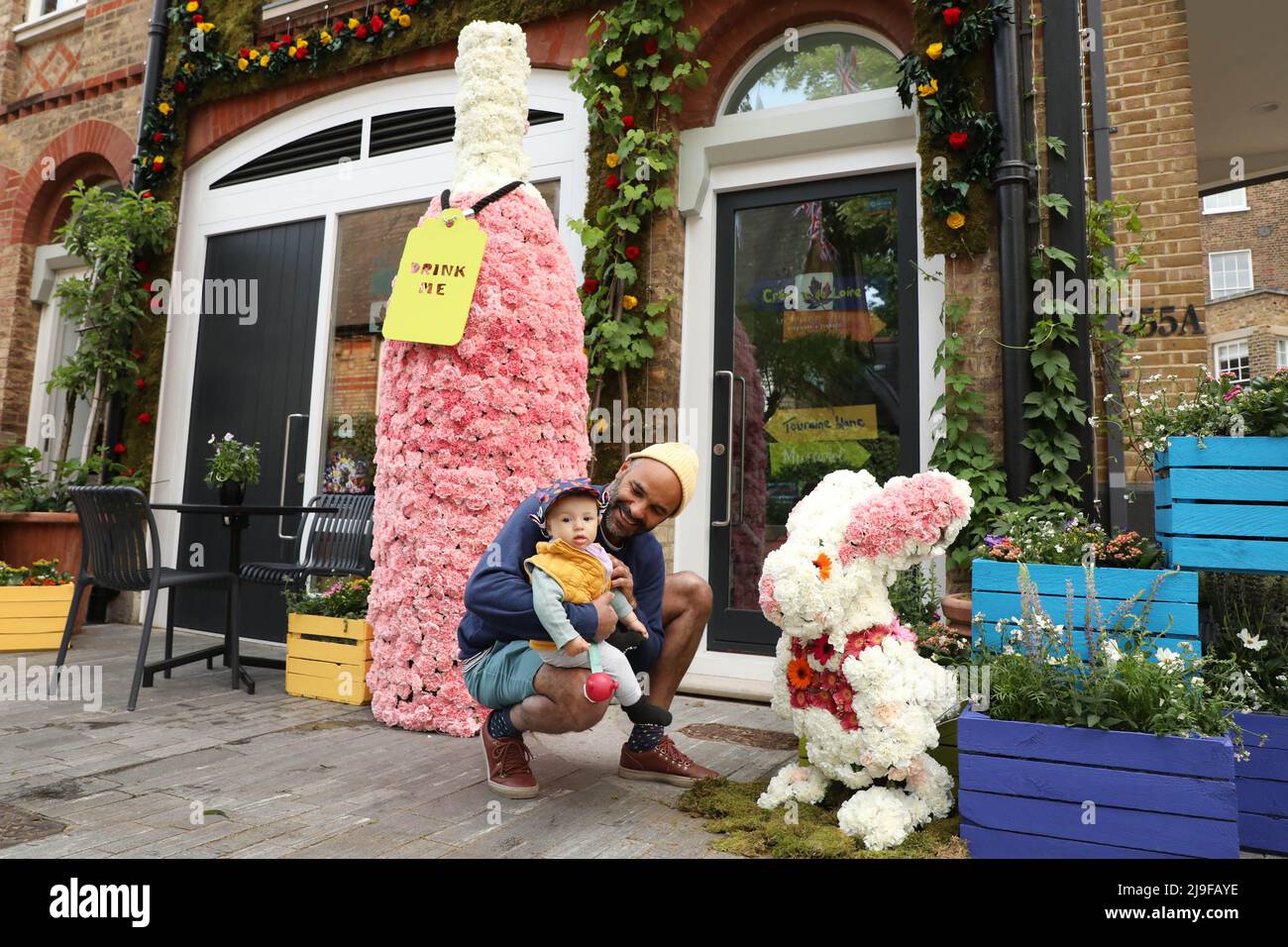 EDITORIAL USE ONLY Pierre Laurent Romain and baby Bay Valentine McGregor Romain at 'Alice in Wine-derland', a floral installation commissioned by Loire Valley Wines as part of this year's Chelsea in Bloom , London. Picture date: Monday May 23, 2022. Stock Photo