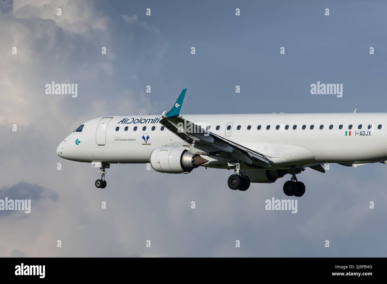 Air Dolomiti Embraer 190 airliner landing in Graz in Austria in front of blue skies Stock Photo