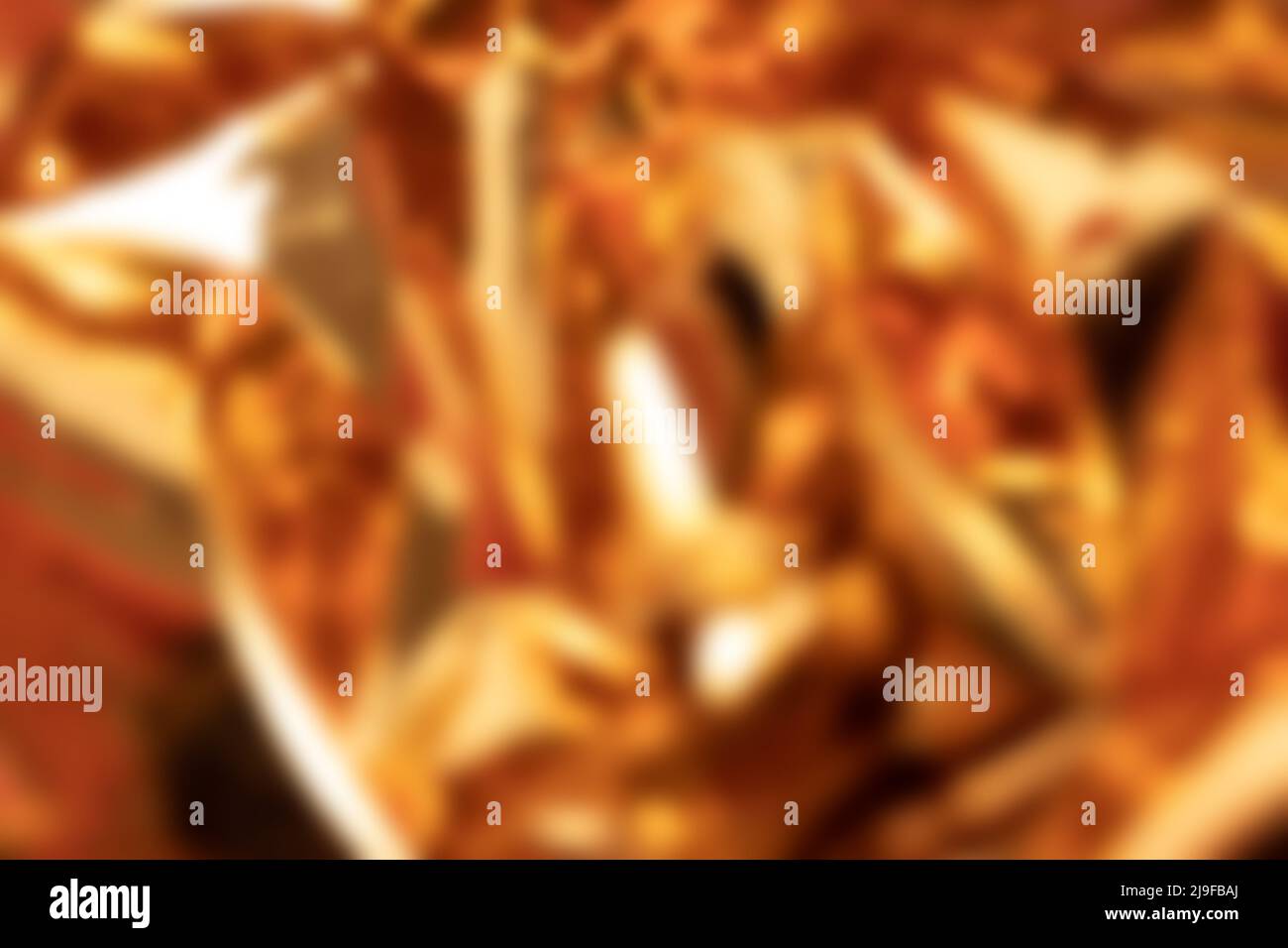 Blurred golden foil shimmer texture. Soft focus backdrop. Stock Photo