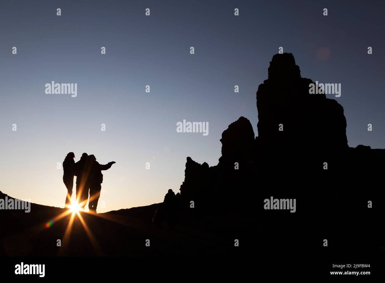 A group of people view the Las Rochas rock formation in Teide National Park in Tenerife, Spain. Stock Photo