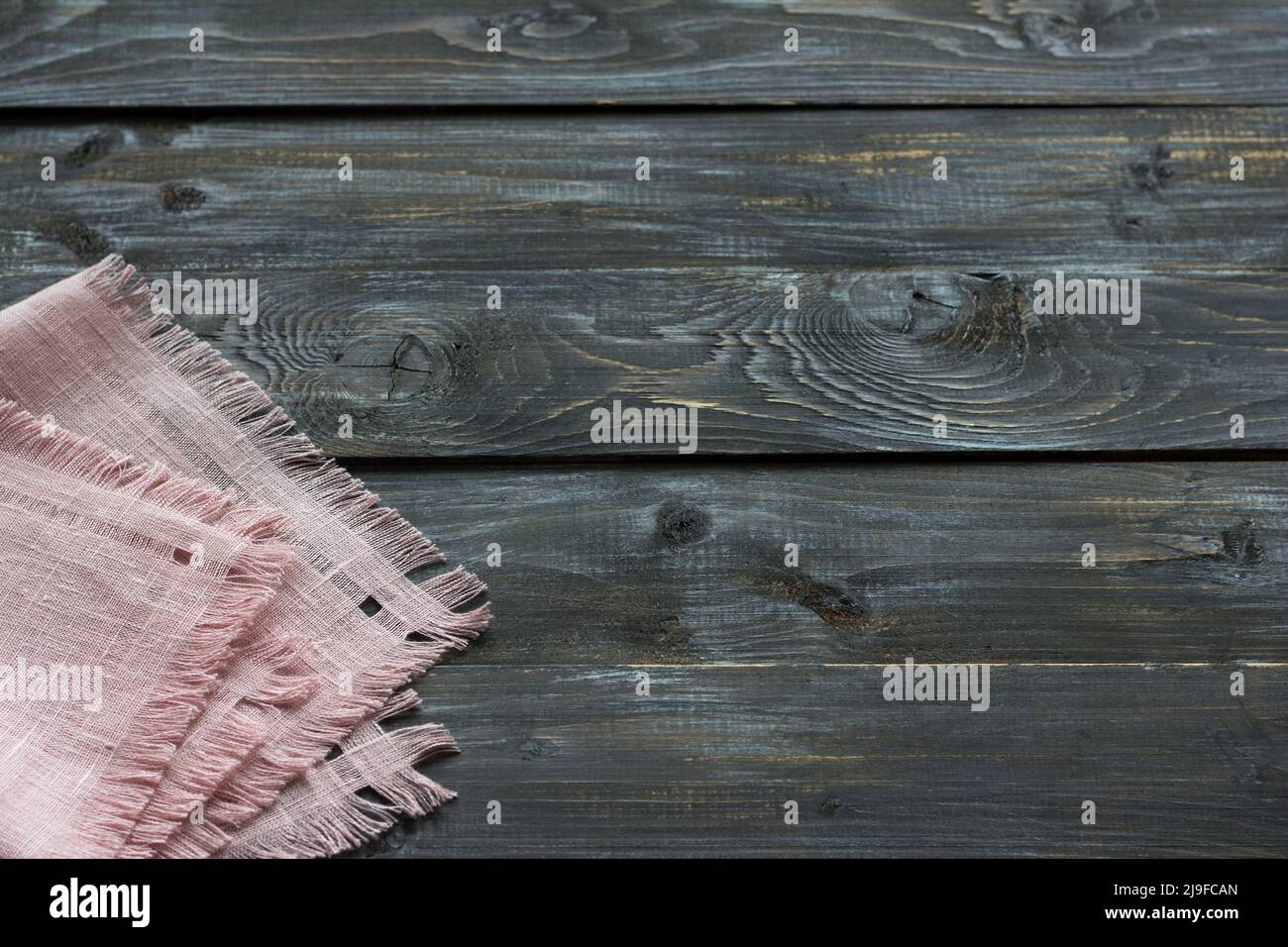 Pink linen napkin with fringe on a wooden background, rustic style, top view, space Stock Photo