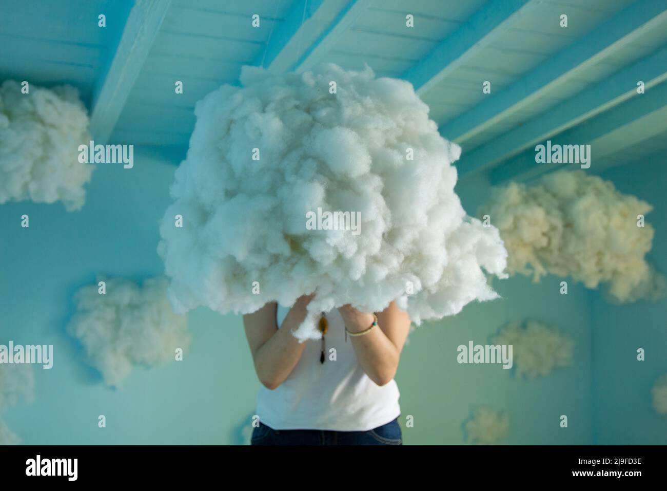 Cotton clouds, in the blue-painted room, a cotton cloud over her head,  cotton puddles on the floor, blue jeans, white blouse, penthouse Stock  Photo - Alamy