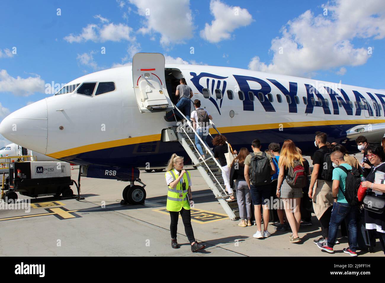 Passengers (tourists) are boarding airplane of Ryanair (the Irish Low Cost Airline Carrier) in