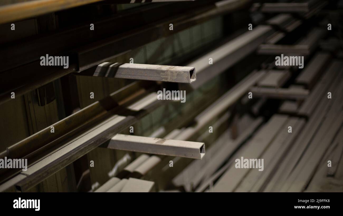 Steel profile on shelves. Metal storage details. Warehouse in shop. Metal beams in room. Stock Photo