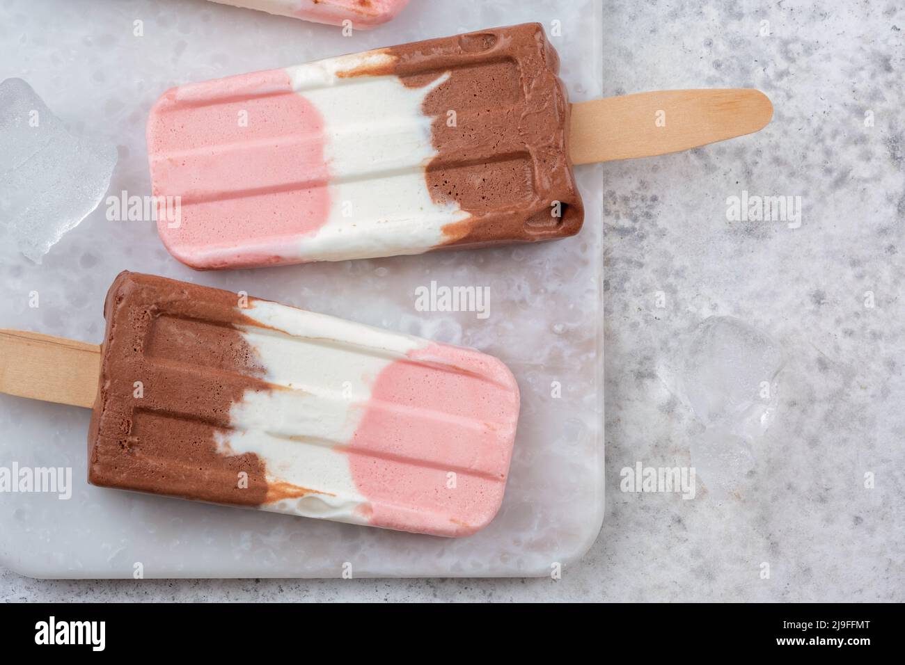 Neapolitan yogurt ice cream popsicle from vanilla, chocolate, and strawberry Stock Photo