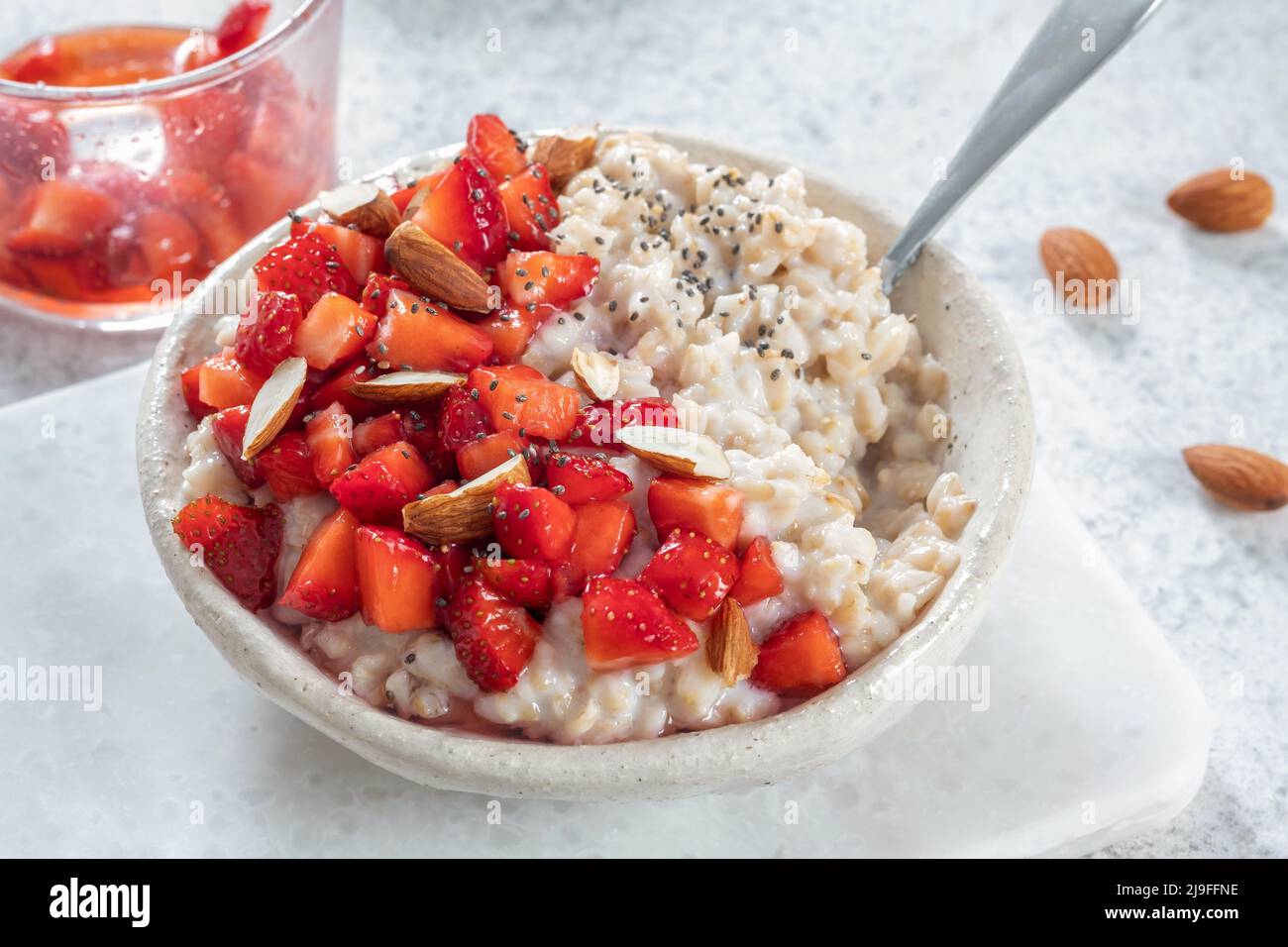 Oatmeal porridge with strawberries top view. Porridge oats in bowl. Healthy food breakfast Stock Photo