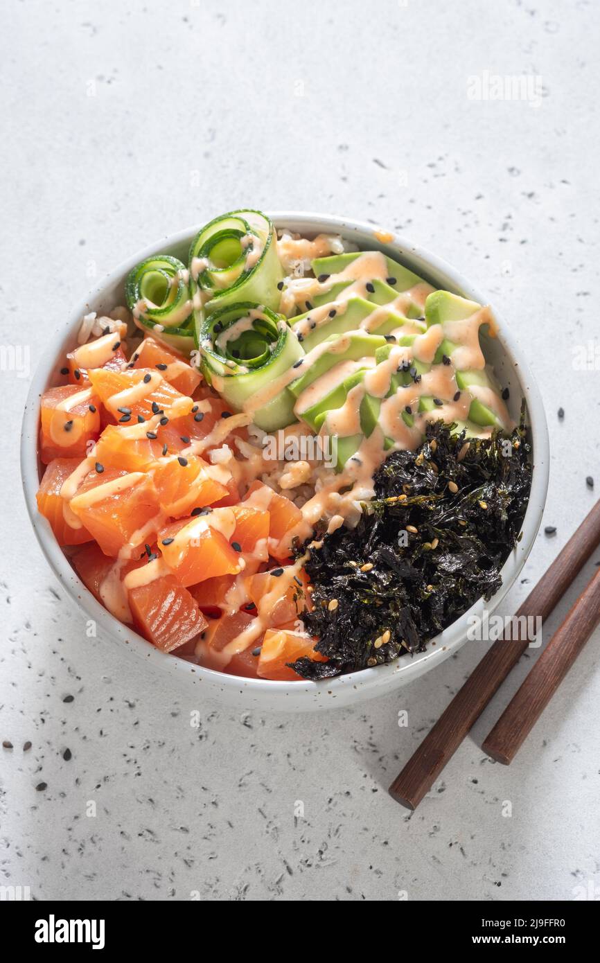 Hawaiian Salmon Poke Bowl with avocado, cucumber, rice and sesame seeds